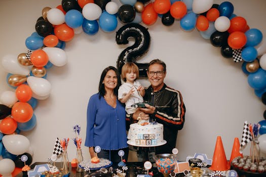 A joyful family celebration with balloons and cake for a child's second birthday.