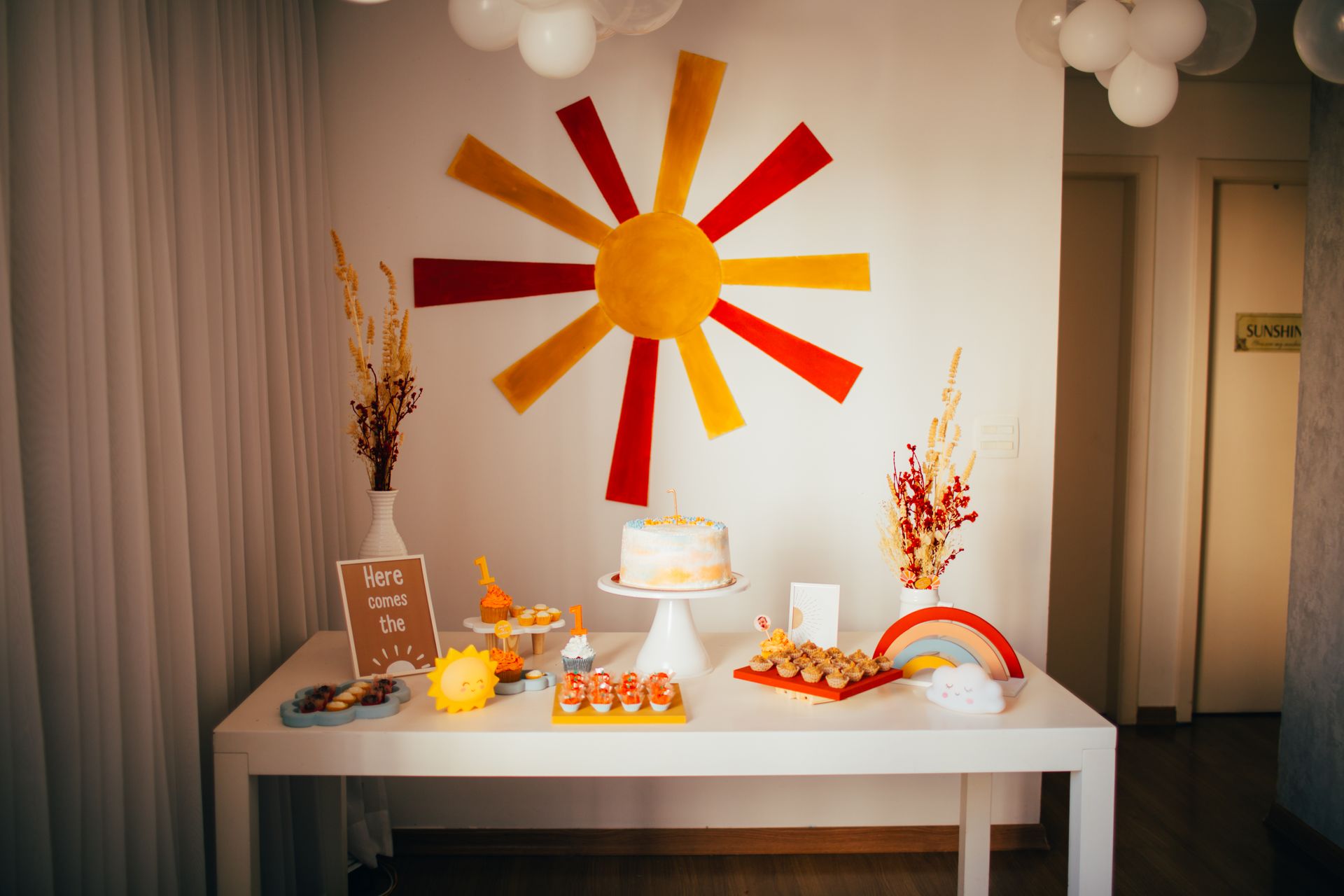Bright and playful birthday party setup with sun and rainbow theme decorations.