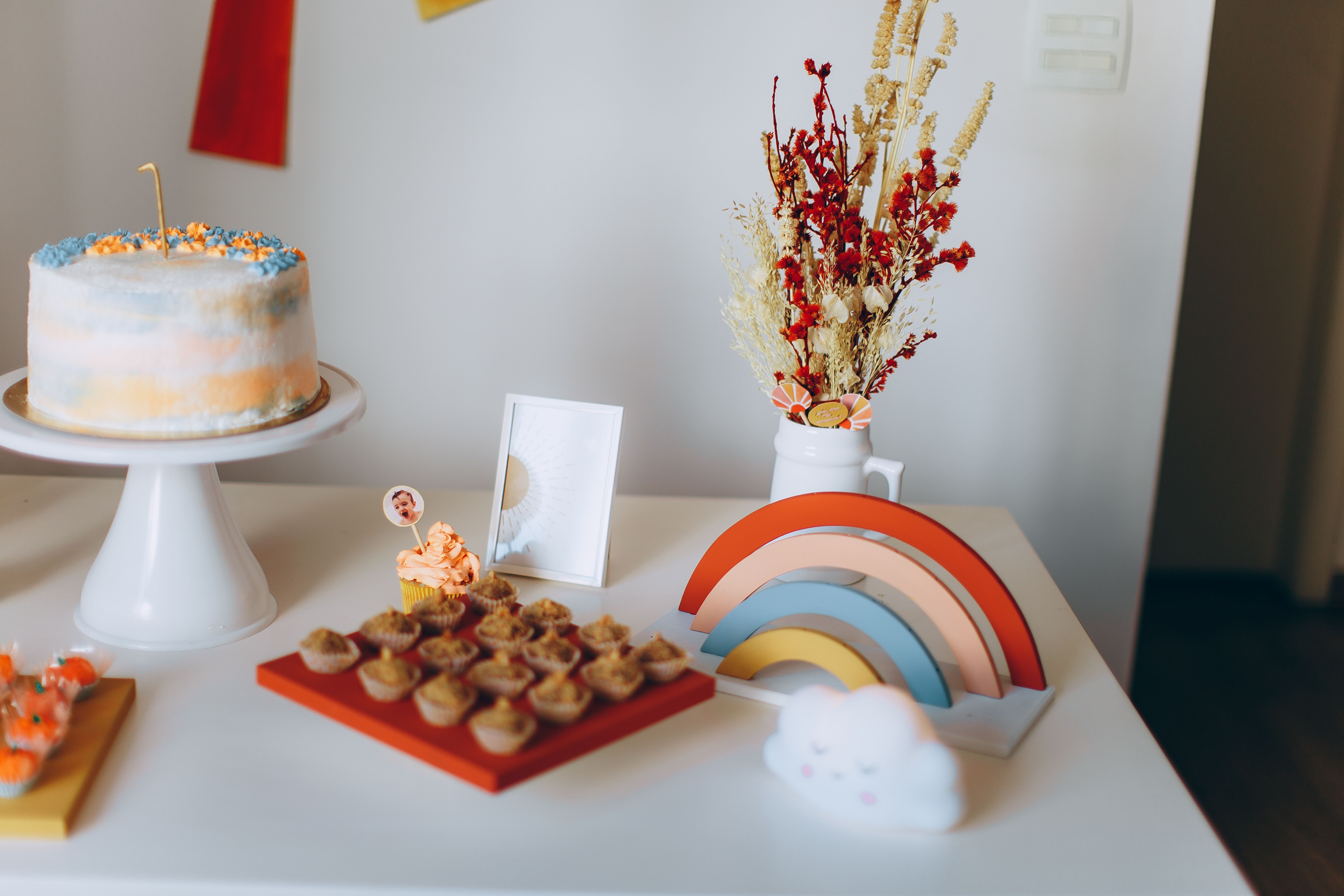 Vibrant dessert table with a cake, cupcakes, and decorations perfect for a celebration.