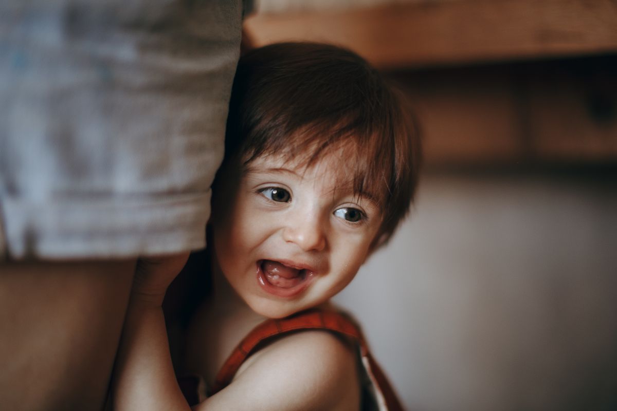 Joyful toddler peeking and laughing during a game of peekaboo