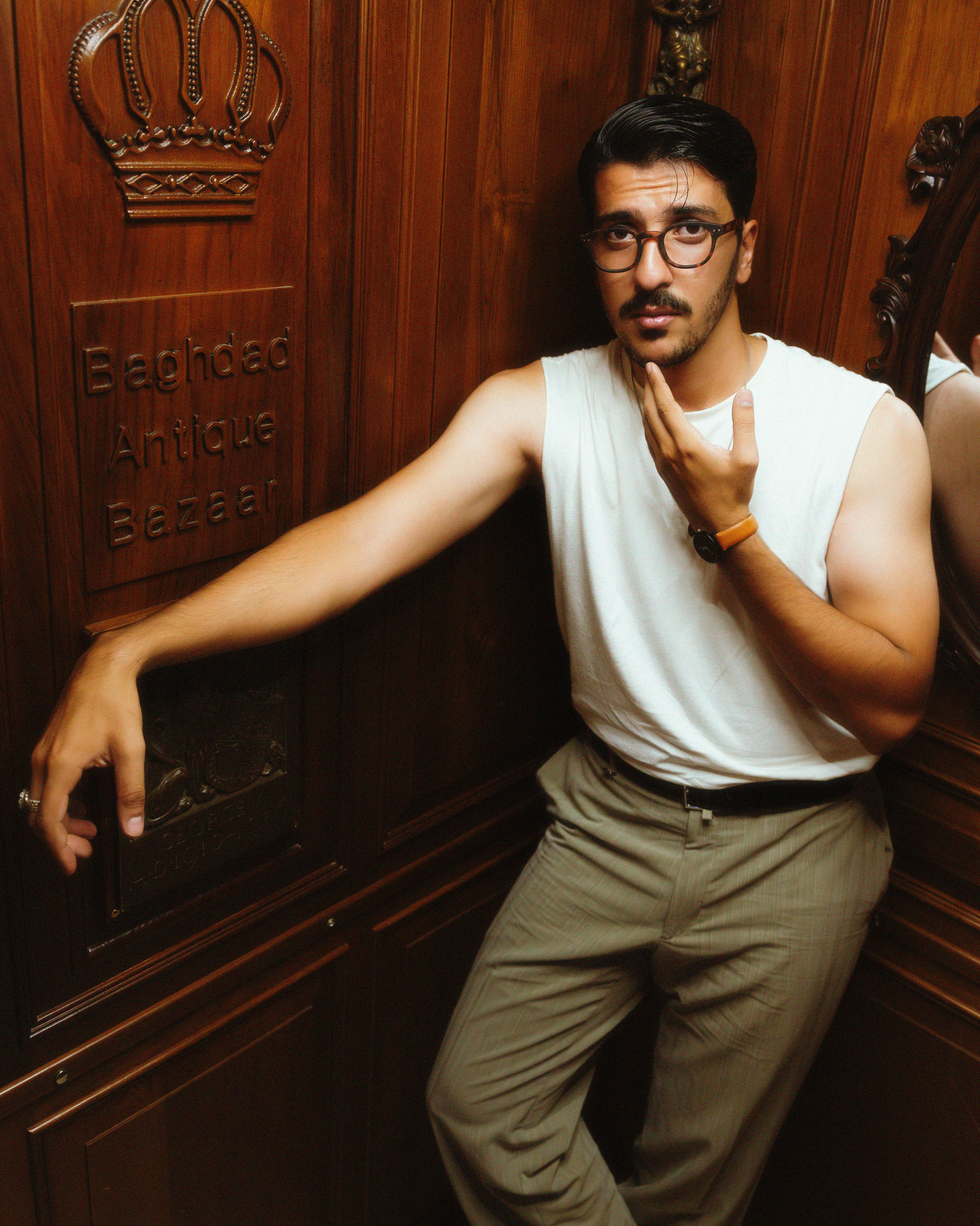 Portrait of a stylish man posing indoors at the Baghdad Antique Bazaar.