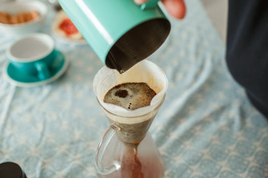 Close-up of fresh coffee brewing in a pour-over method, showcasing a cozy home atmosphere.