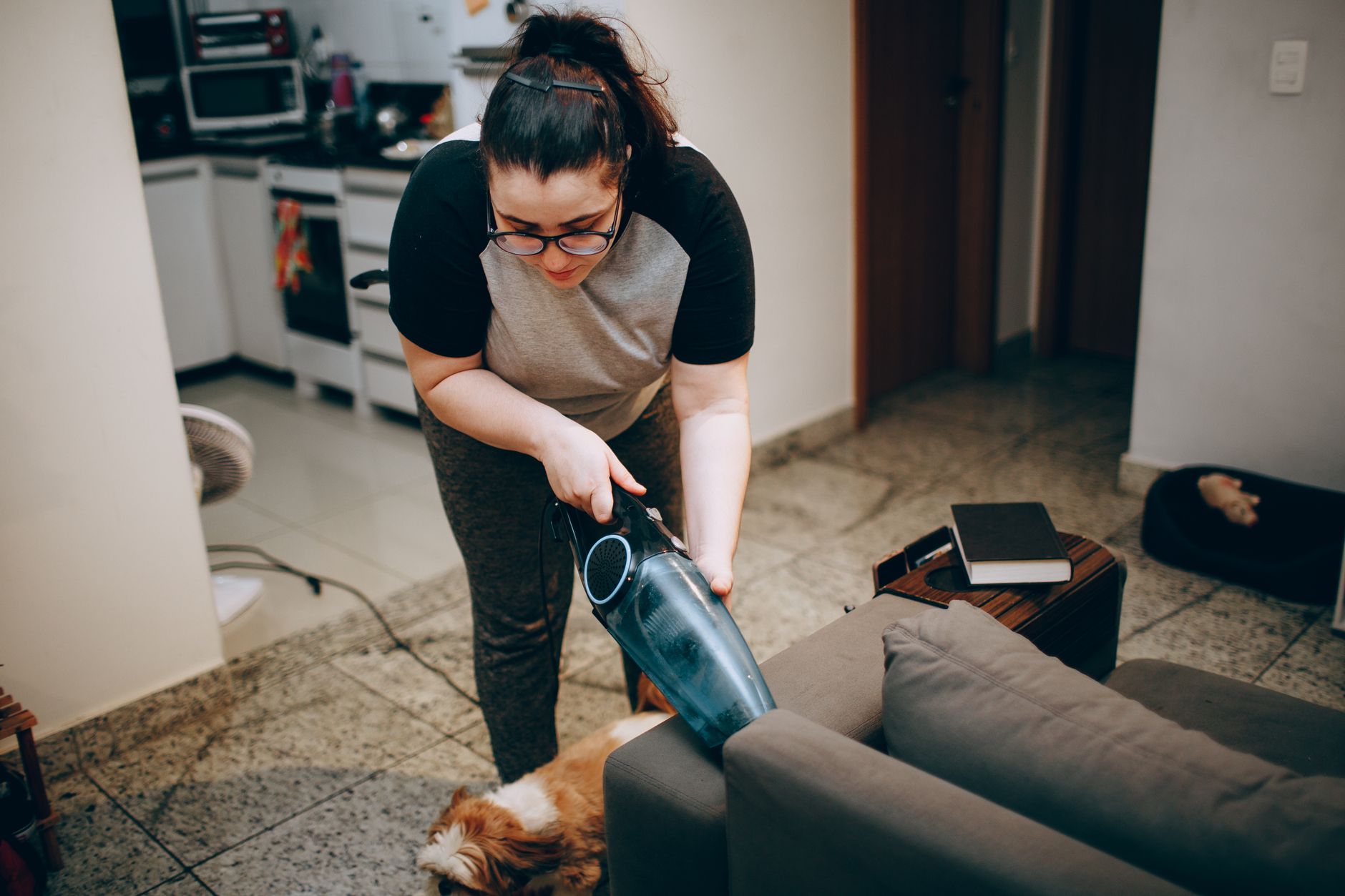 cleaning dog hair off a fabric sofa with rubber tool