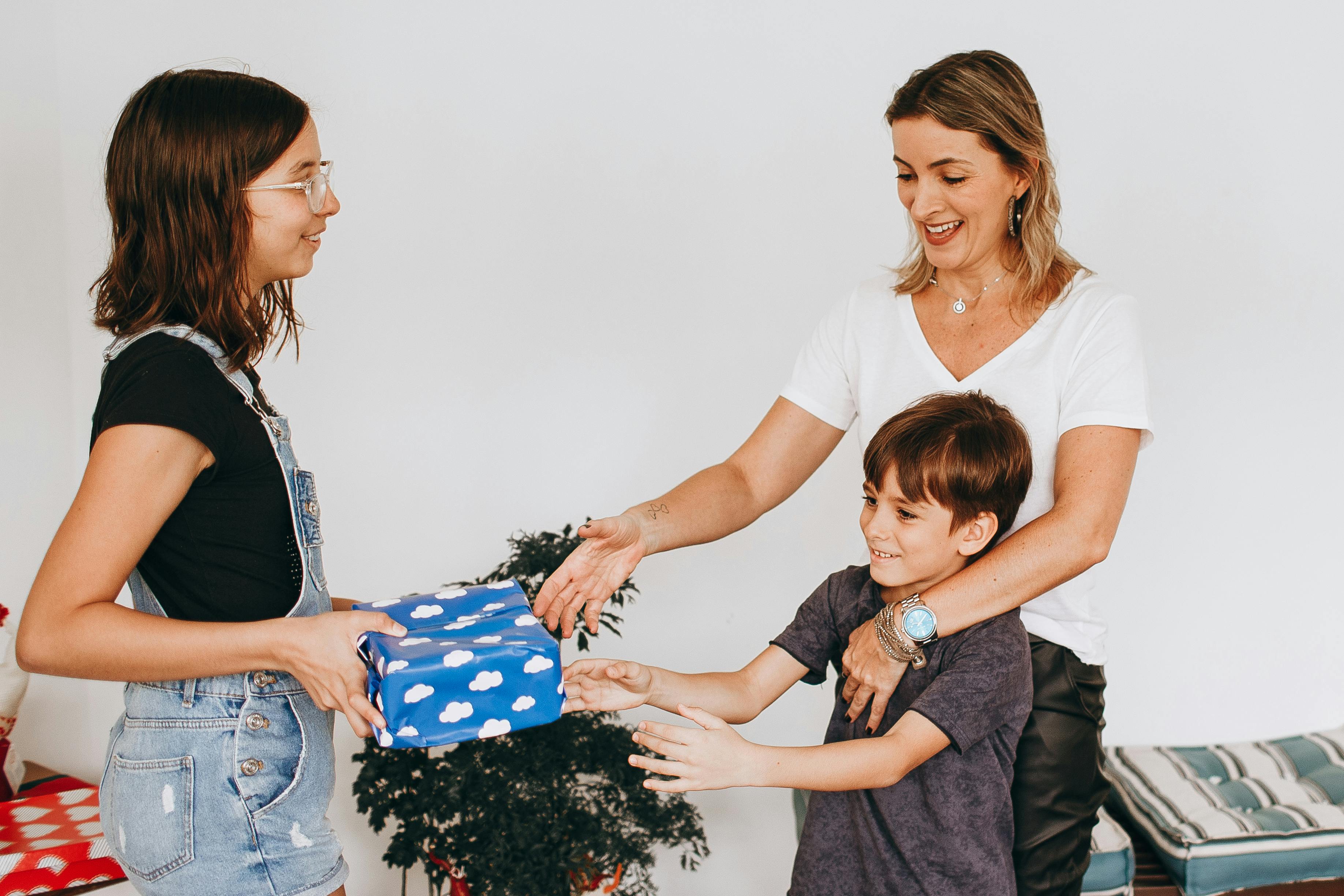 A woman giving a gift to a child