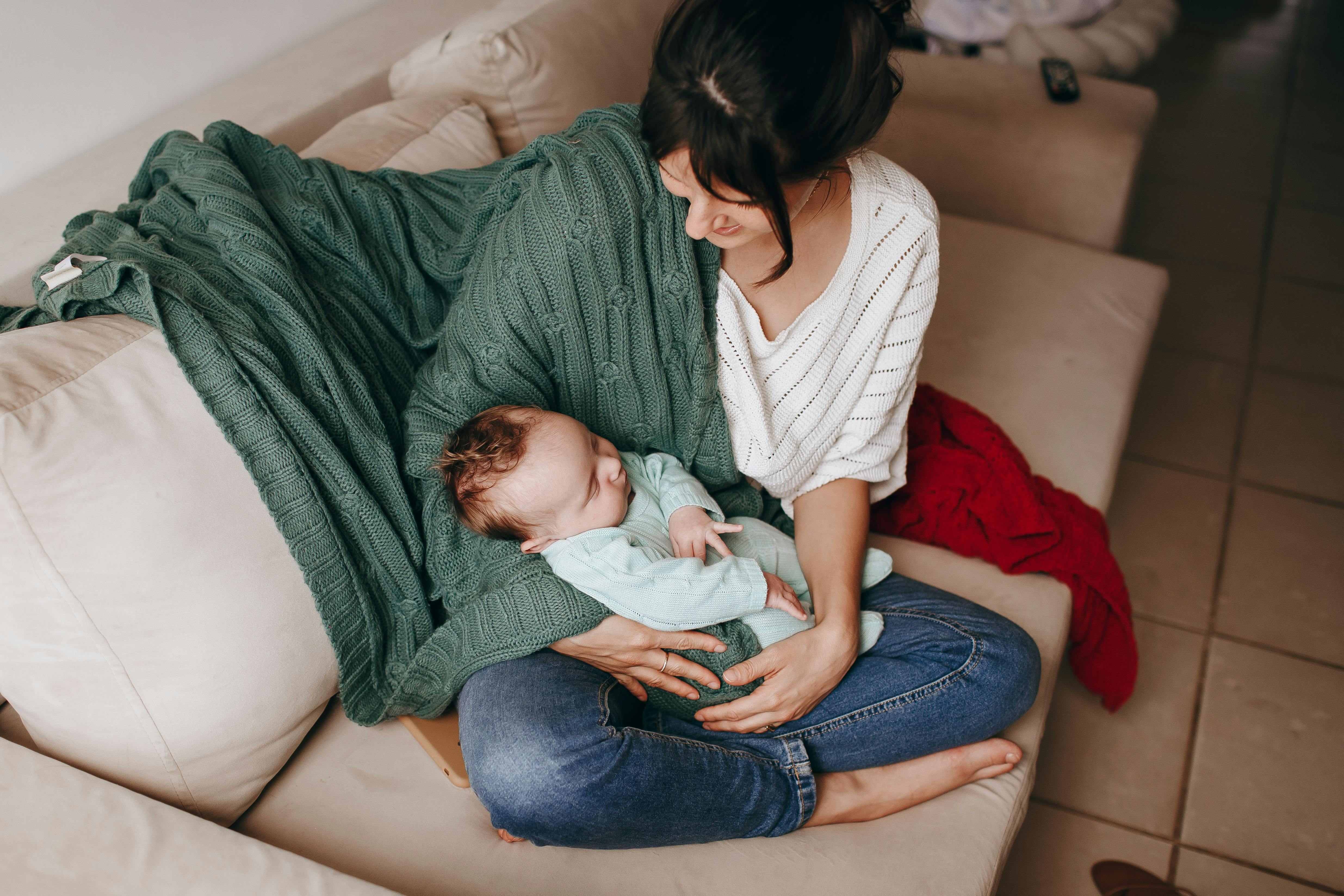 woman sitting of sofa with a baby