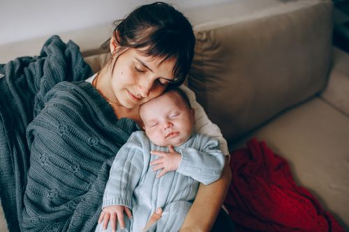 Free A comforting moment between mother and newborn, wrapped in soft blankets indoors. Stock Photo