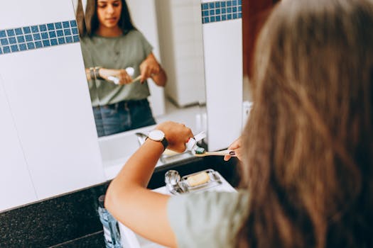 Teen girl brushing teeth in a modern bathroom, emphasizing daily hygiene routine.
