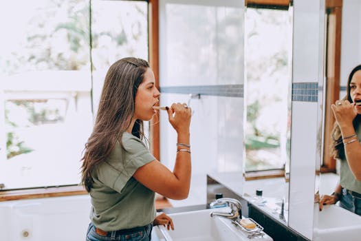 A woman enjoying her morning routine of brushing teeth in a bright, contemporary bathroom.