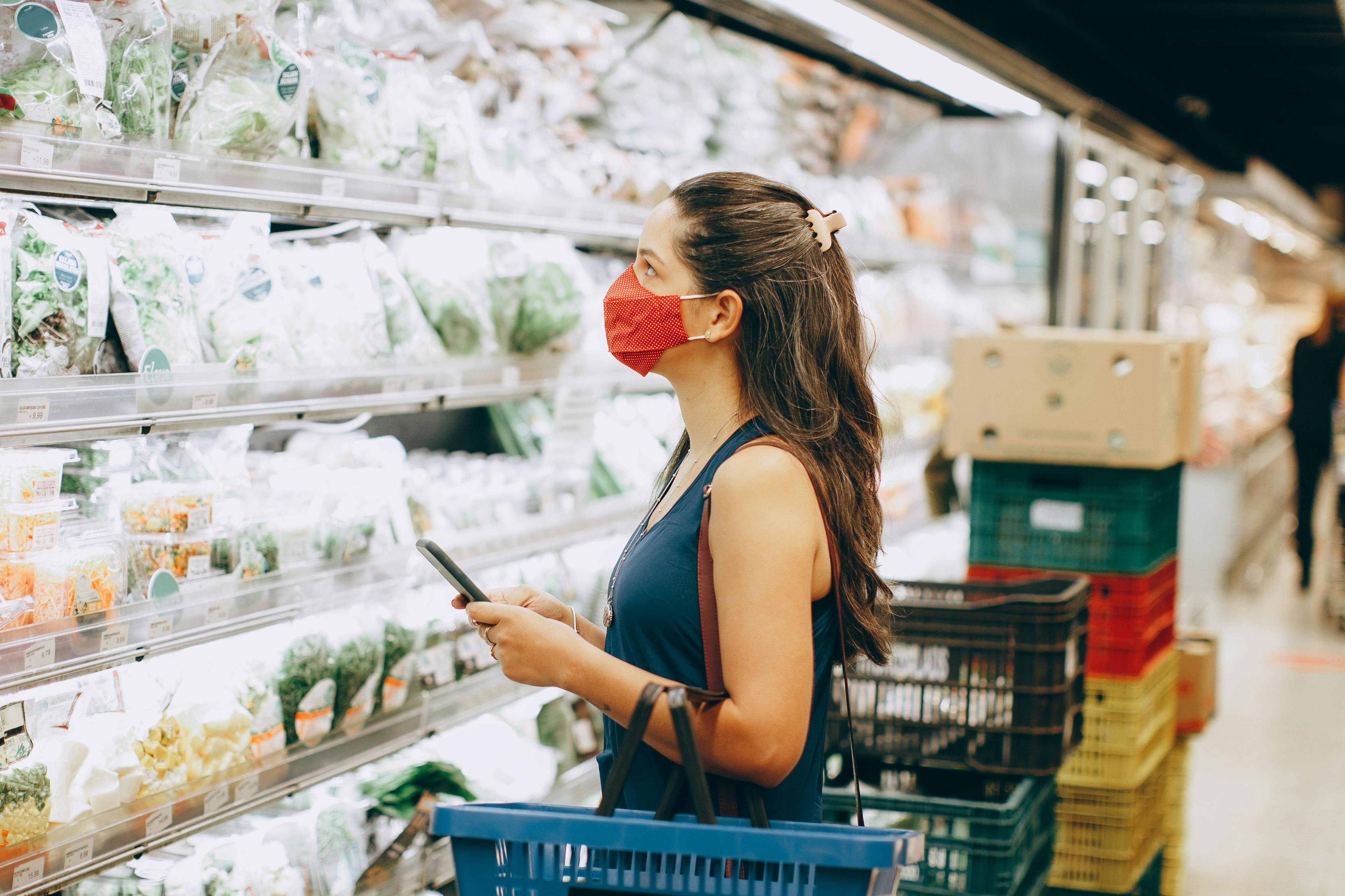 Woman wearing face mask shopping in supermarket
