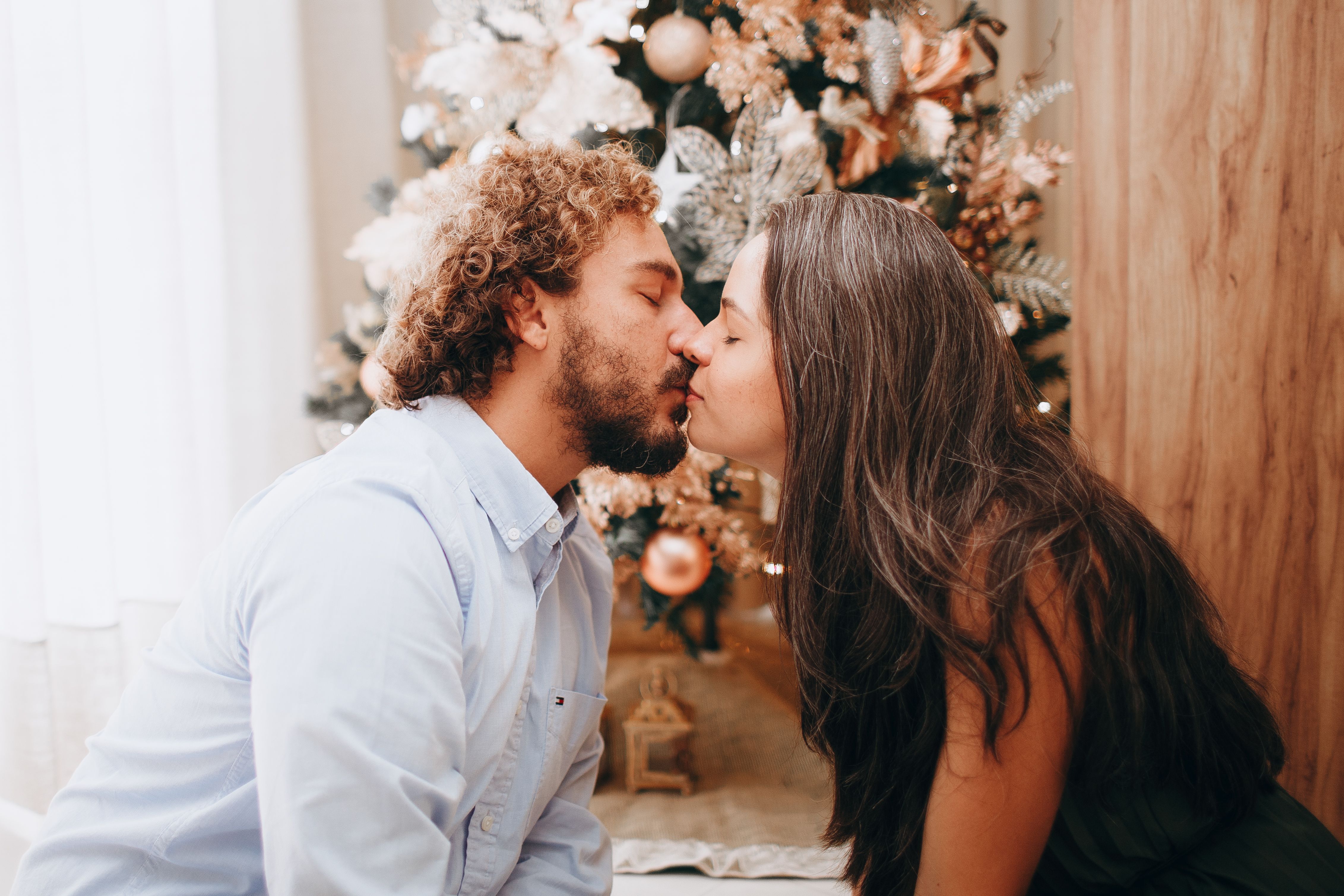 Kissing Couple by the Christmas Tree · Free Stock Photo