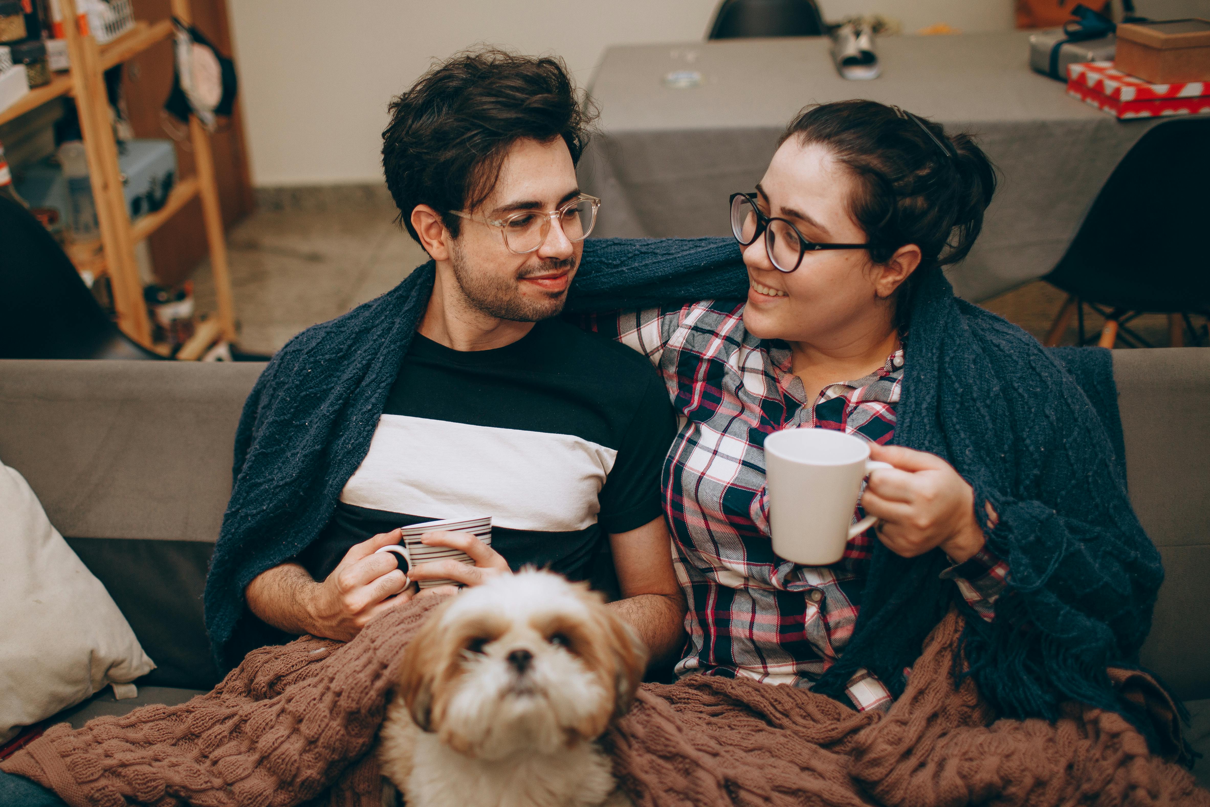 Couple sitting on couch with dog