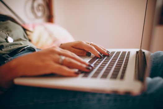 Close-up of a woman typing on a laptop indoors, highlighting connectivity and technology.