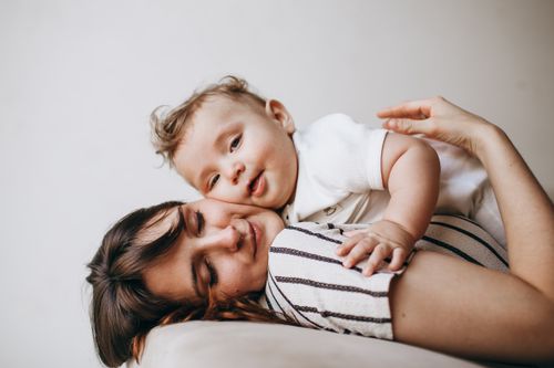 Free A loving moment between mother and baby relaxing together indoors. Stock Photo