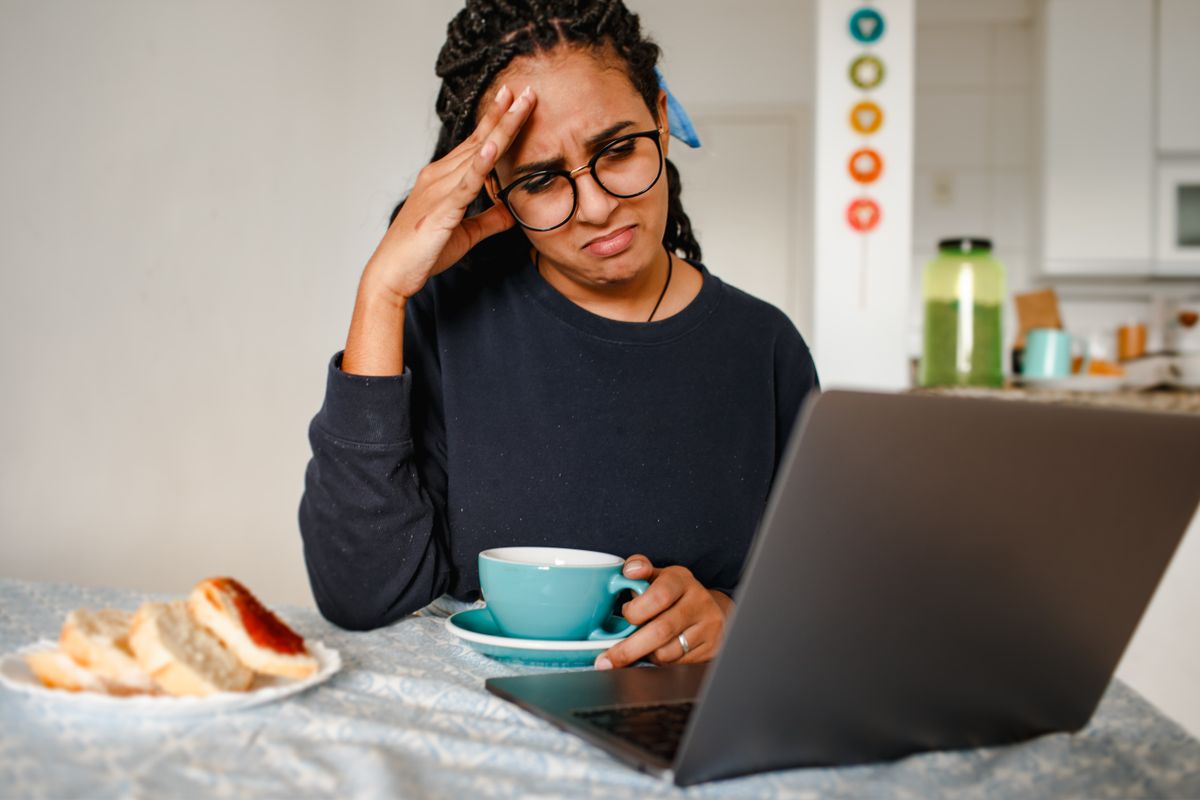 Mujer llevándose las manos a la cabeza con gesto de frustración en casa