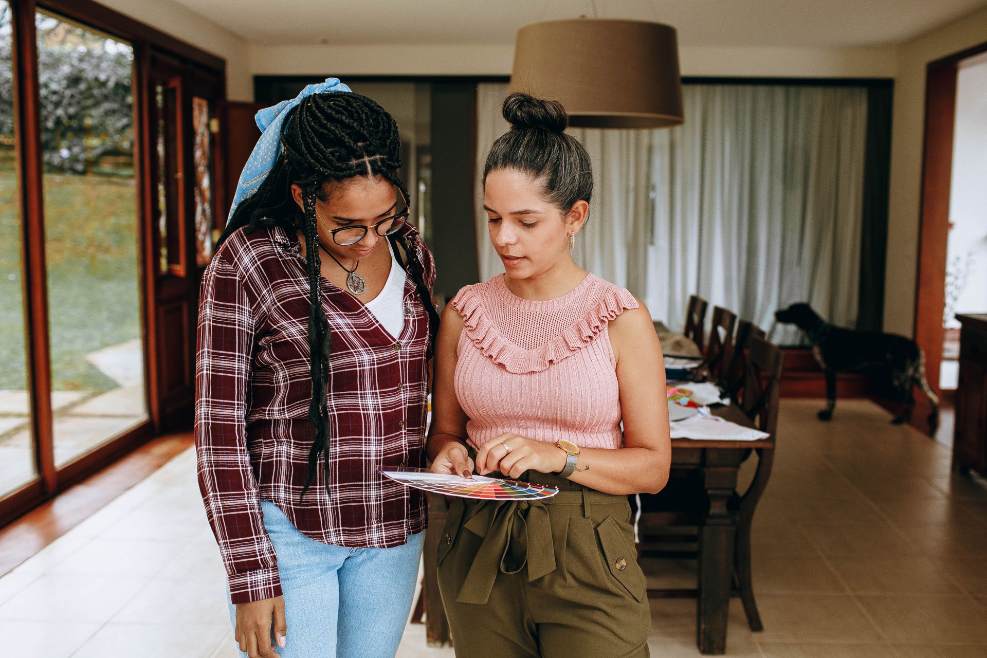 Two women engaged in conversation and reviewing documents in a cozy indoor setting.