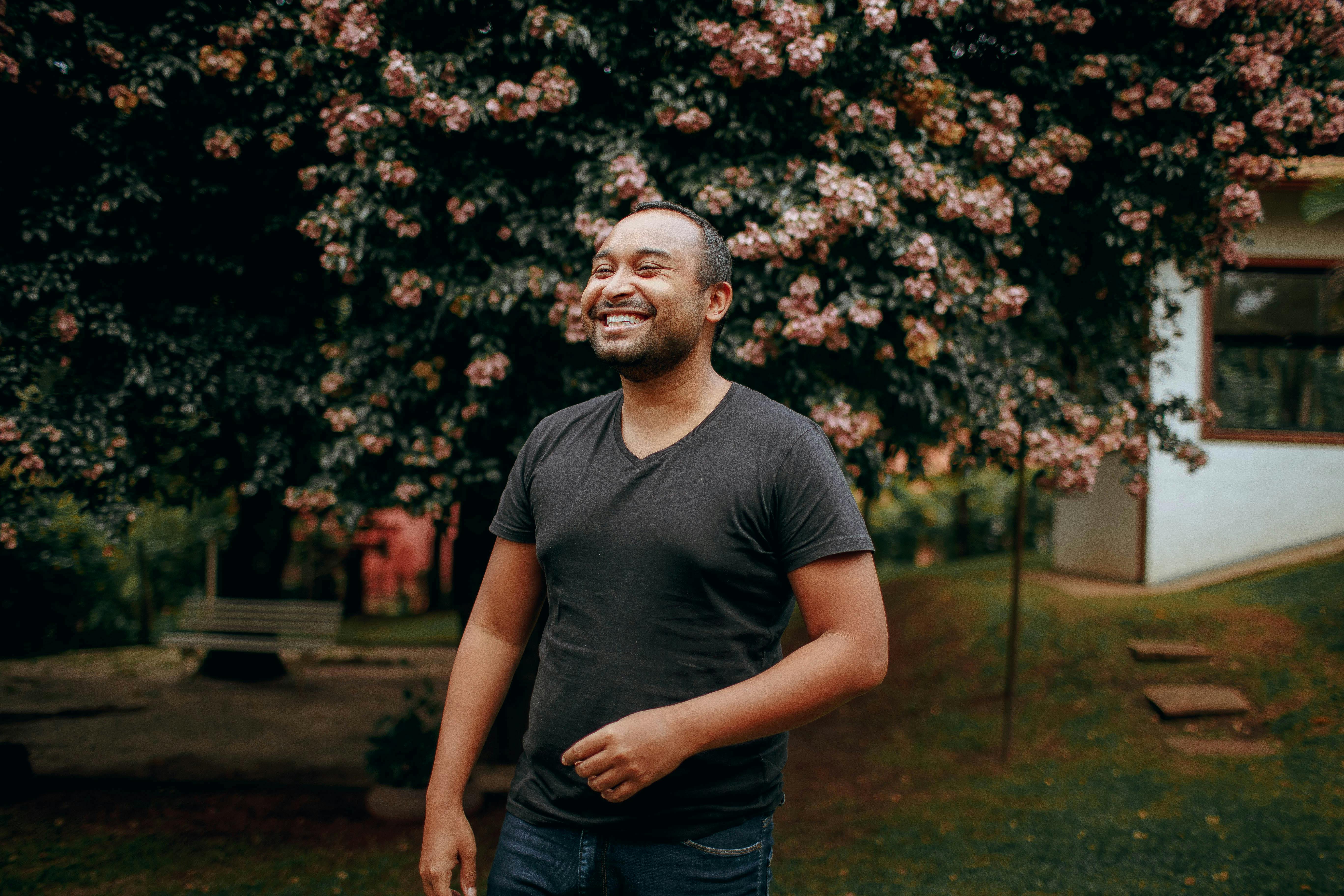 smiling man in black t shirt in garden