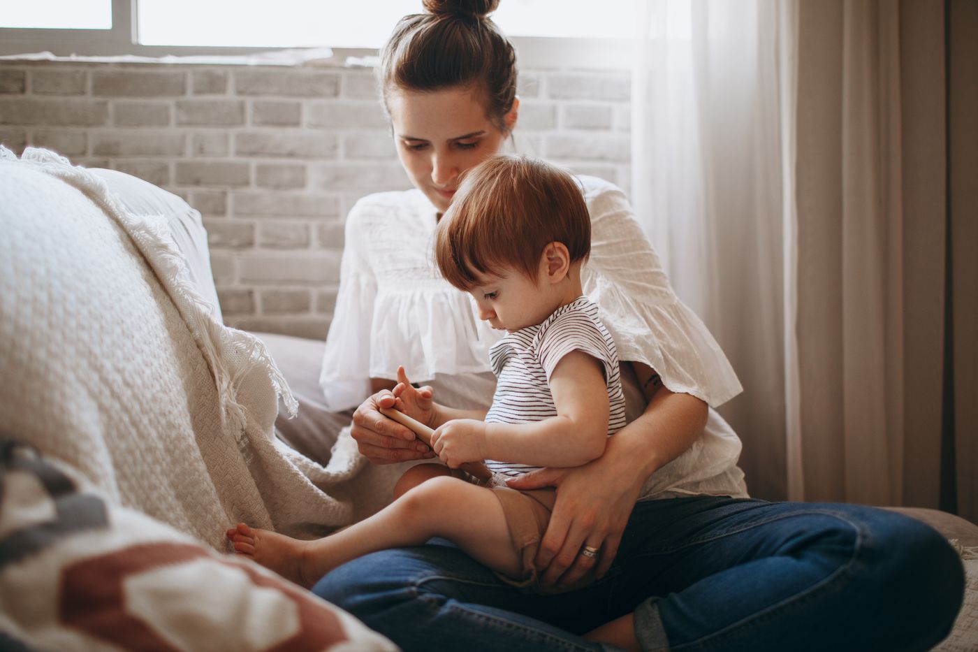 Maman habillée partageant un moment joyeux avec son jeune enfant dans le salon