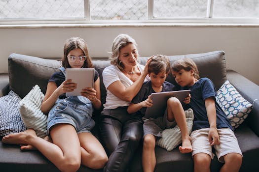 A family of four enjoying tablet time together on a comfortable sofa in a cozy living room.
