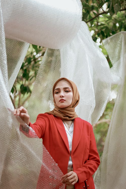 갈색 Hijab를 입고 빨간 코트에 여자의 얕은 초점 사진