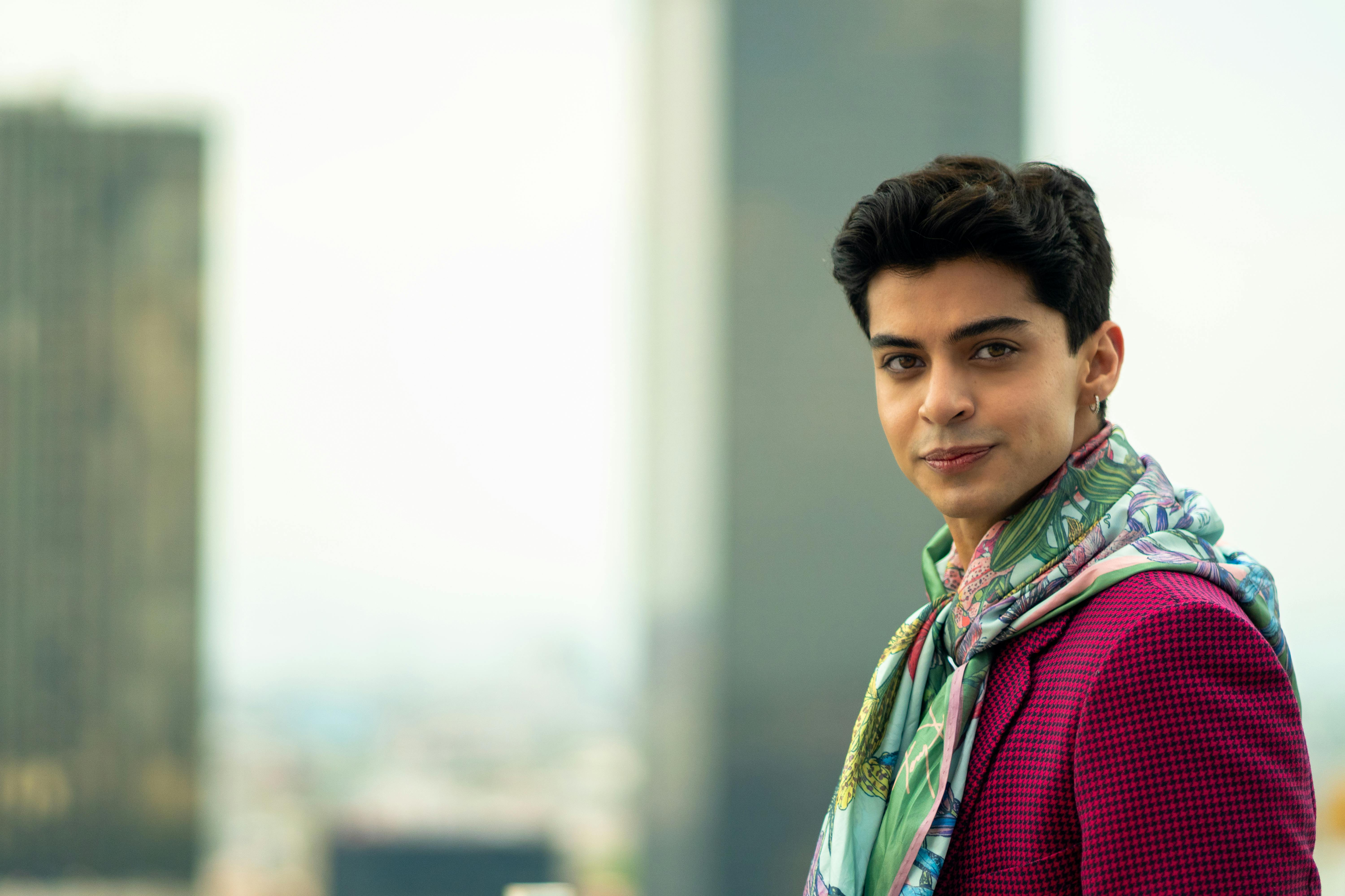 man in pink blazer and colorful scarf