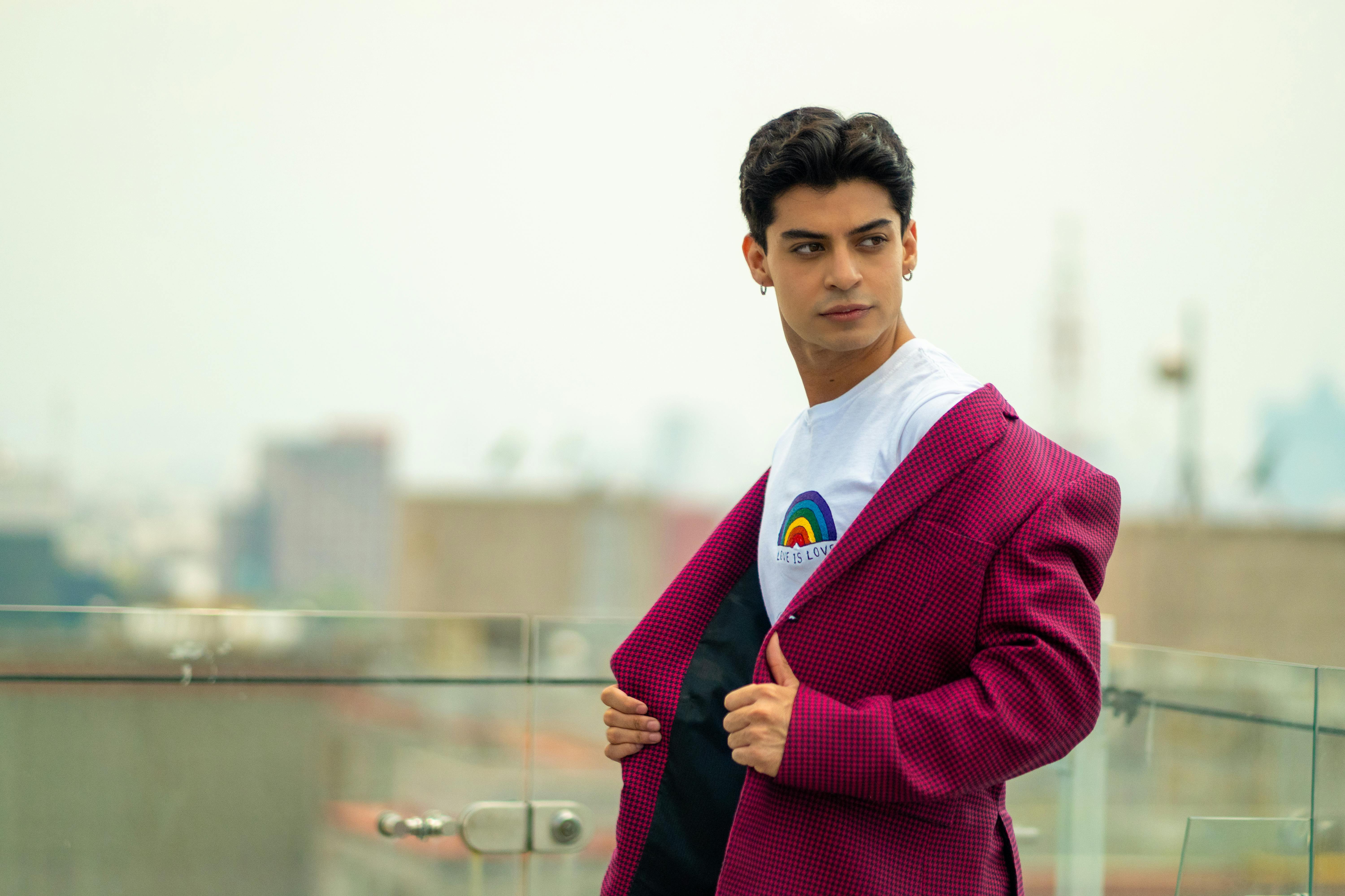 man in pink blazer and shirt with rainbow print