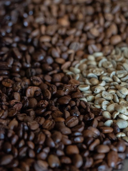 Free Detailed image of coffee beans in different roasting stages, highlighting texture and color distinctions. Stock Photo