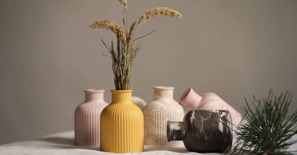 Collection of ceramic vases with dried flowers, capturing a minimalist aesthetic in soft, neutral tones.