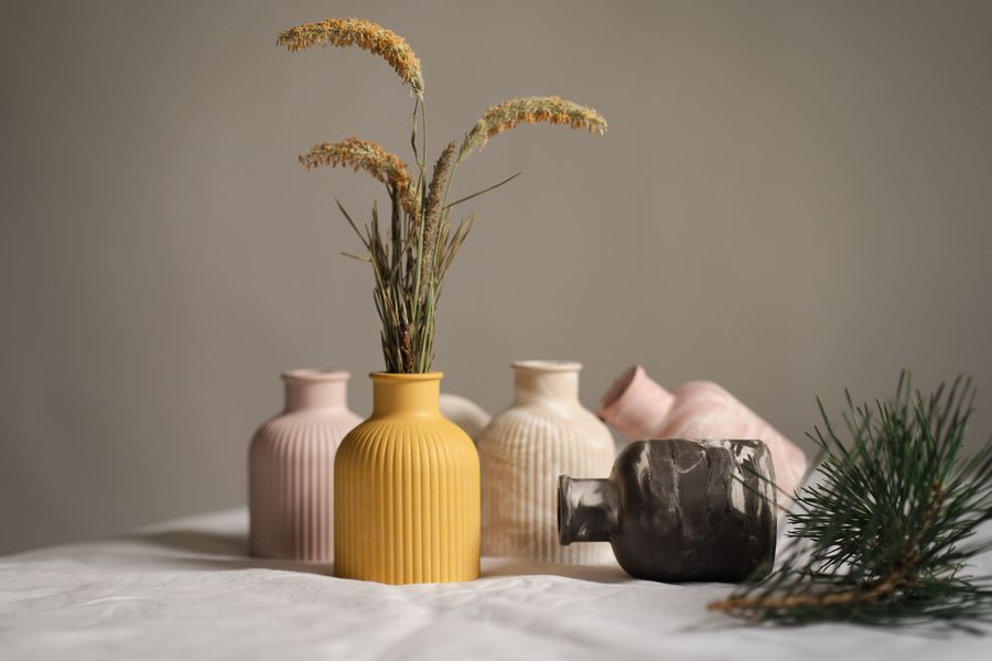 Group of matte ceramic vessels with dried grasses — photo by Ionela Mat on Pexels
