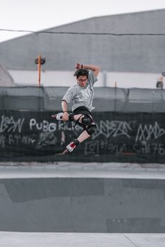 Energetic skater performing an aerial trick at an urban skate park.