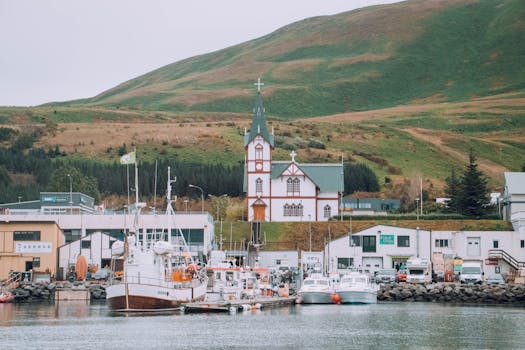 Charming harbor scene with classic church and boats in Húsavík, Iceland.