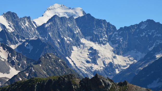 Breathtaking view of towering snow-capped mountains under clear blue skies