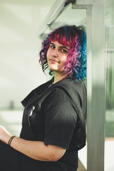 一位年轻女子，头发鲜艳，倚在窗边