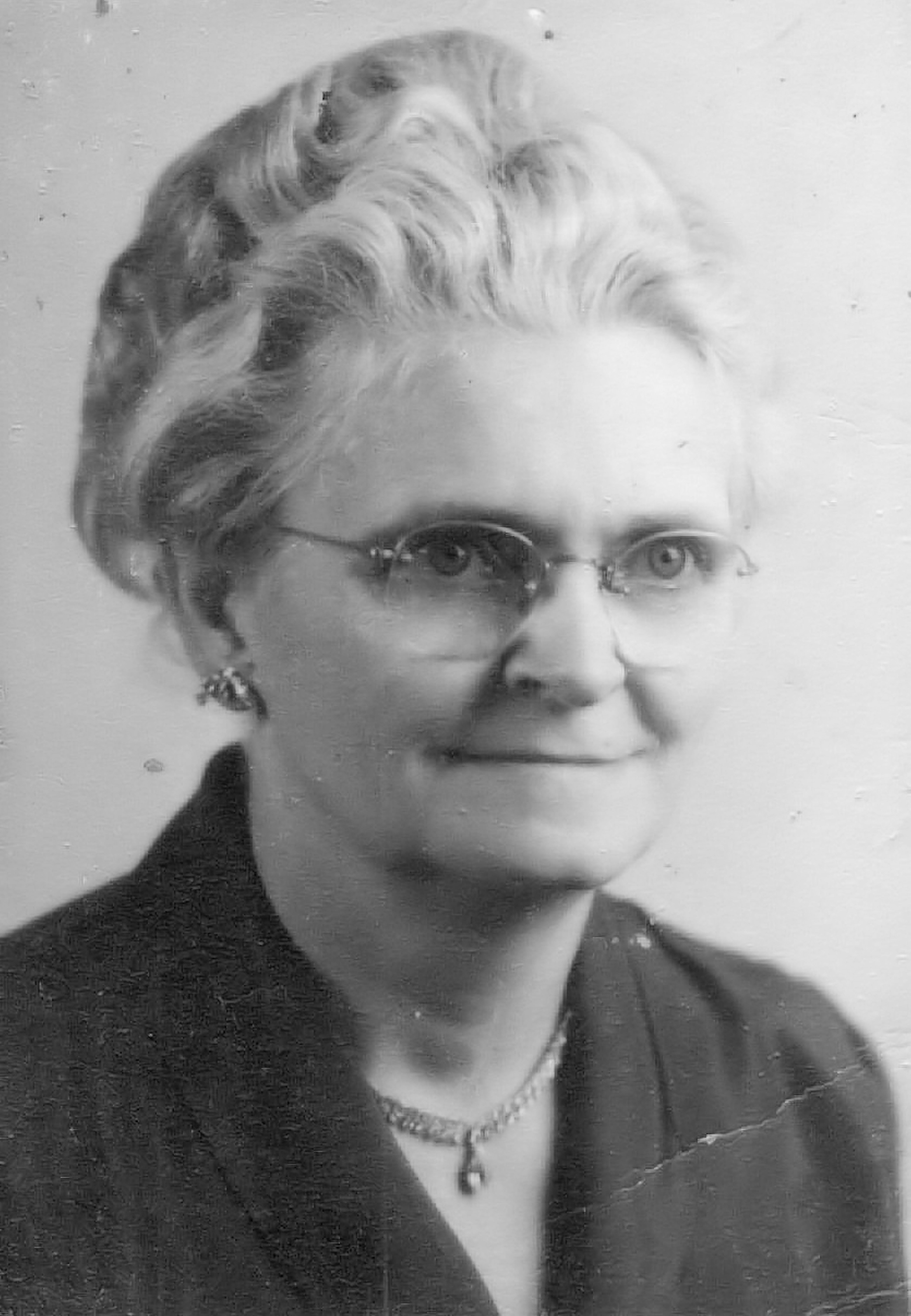 Classic black and white portrait of an elderly woman wearing glasses, exuding wisdom and grace.