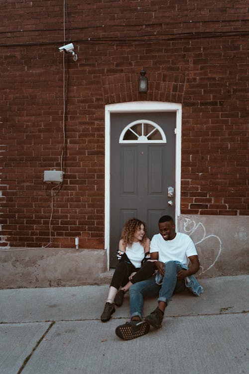Free Smiling Man And Woman Sitting Beside Door Stock Photo