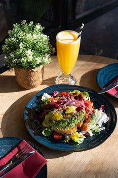 Colorful vegan meal with orange juice and greens at a Barcelona cafe.