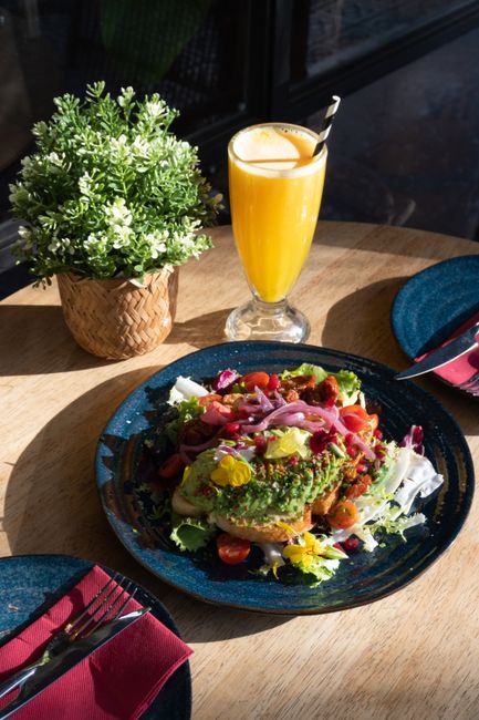 Colorful vegan meal with orange juice and greens at a Barcelona cafe.