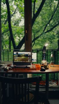 A serene workspace featuring a laptop and coffee with a garden view, ideal for productivity.