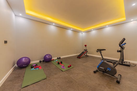 Spacious home gym with yoga mats, exercise balls, and fitness equipment under calming ambient lighting.
