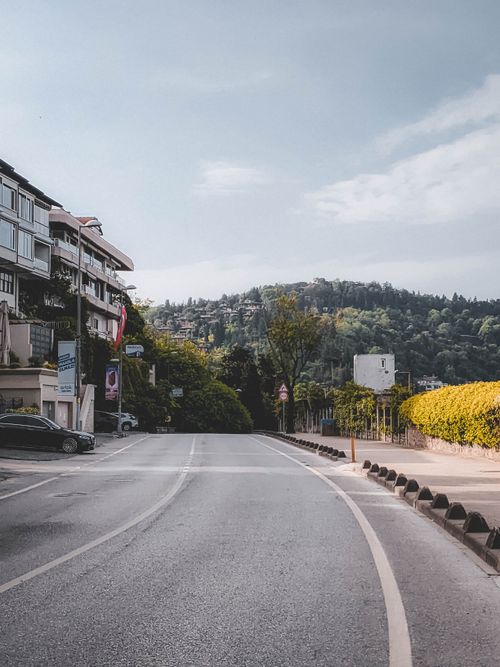 Free Empty urban street with hillside view and buildings under clear sky, perfect for travel and cityscape themes. Stock Photo