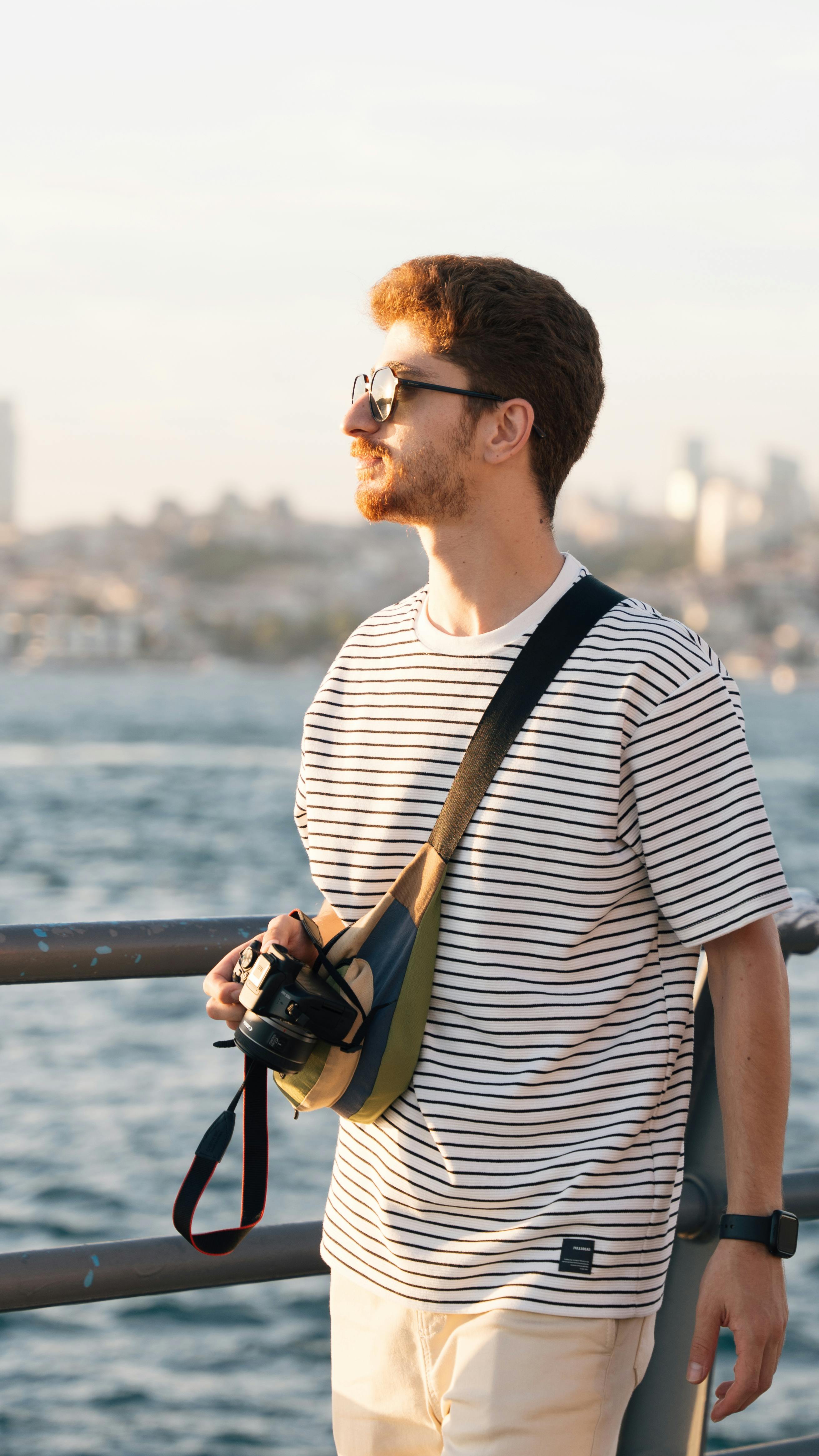 a man with a camera standing on a pier