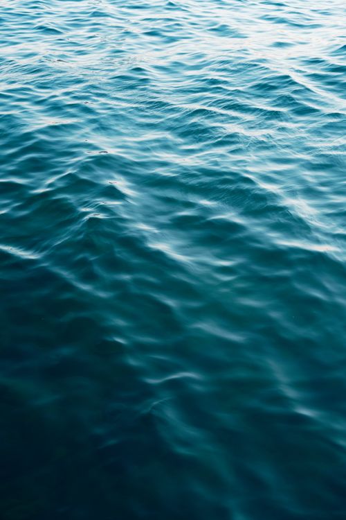 Free Serene sea surface showcasing gentle turquoise ripples and waves, embodying tranquility and liquidity. Stock Photo