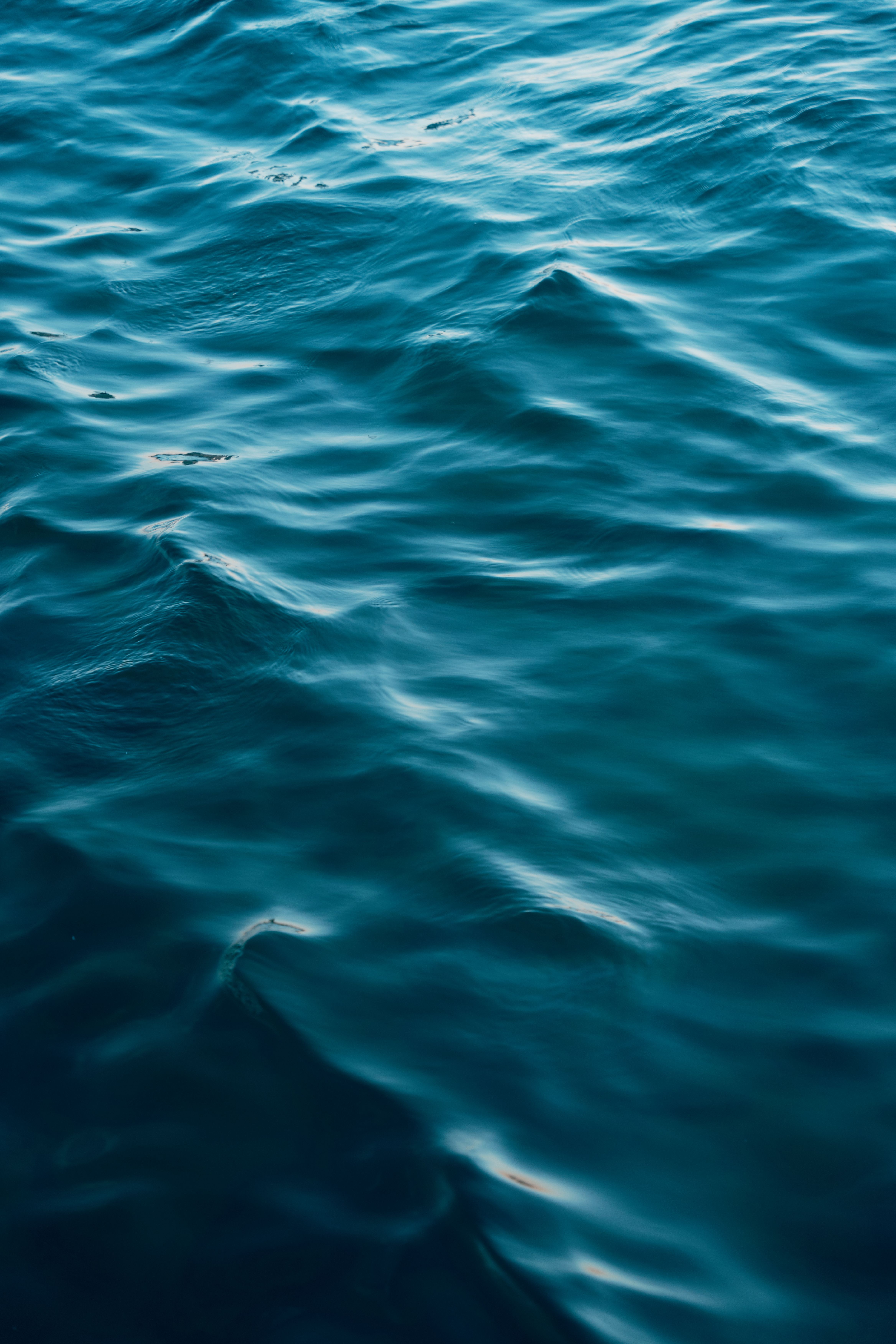 Close-up of serene ocean waves with a turquoise hue, showcasing natural water textures.