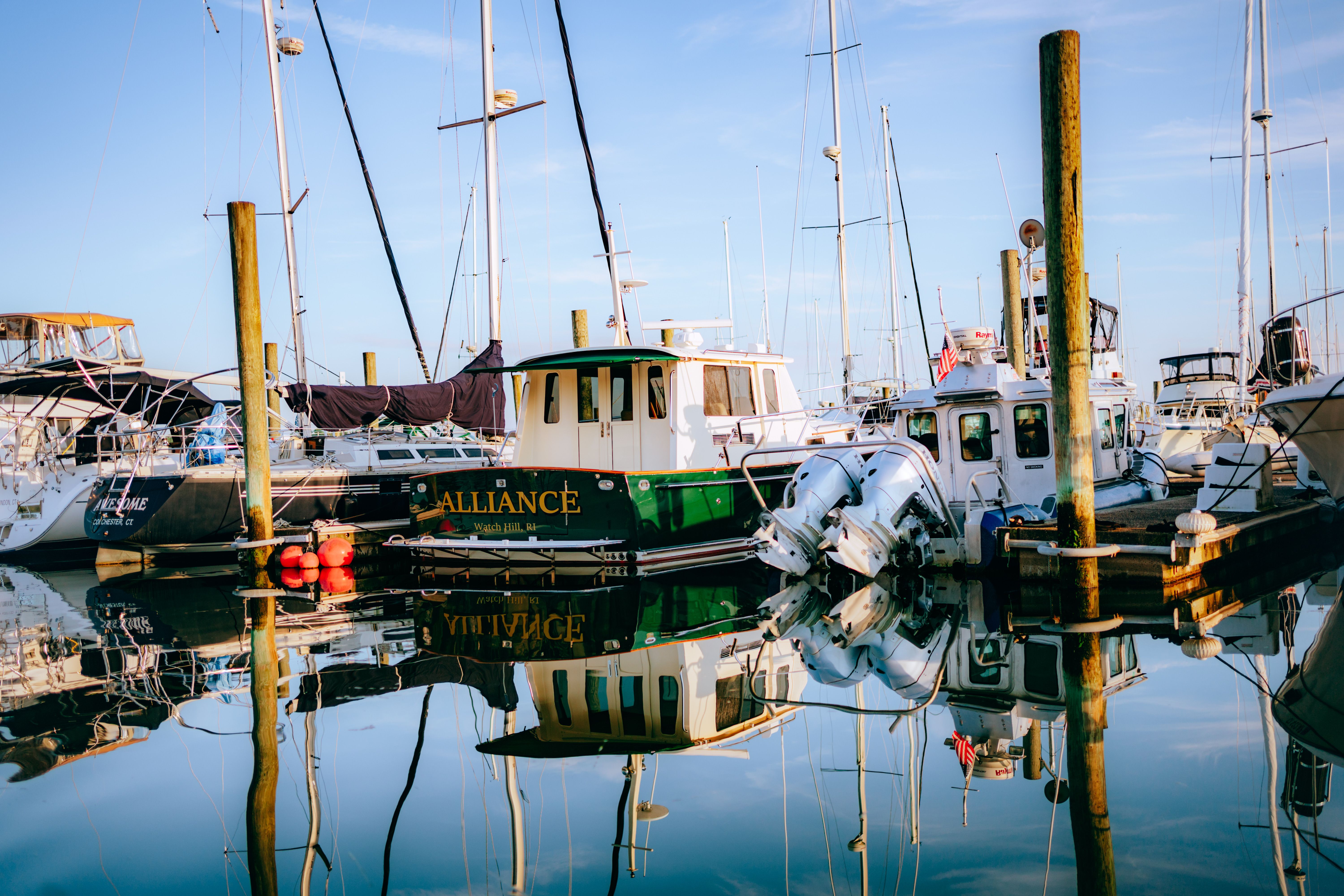Boats docked at a marina with blue water · Free Stock Photo