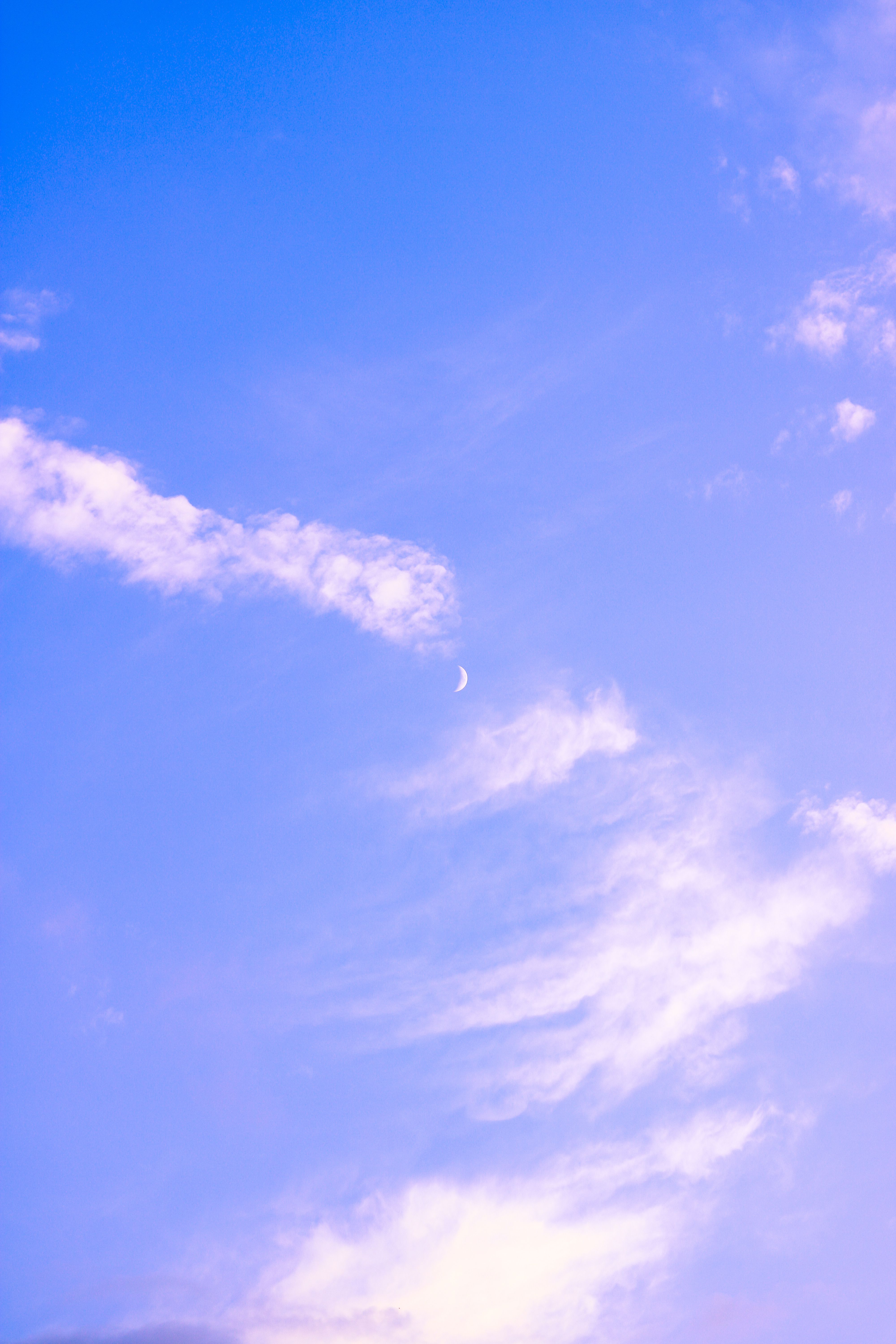 Fotomural Una escena de cielo tranquila con nubes suaves y una luna creciente, evocando paz.