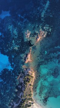 A stunning aerial photograph capturing the vibrant colors and textures of Corse's coastal waters and landscape.