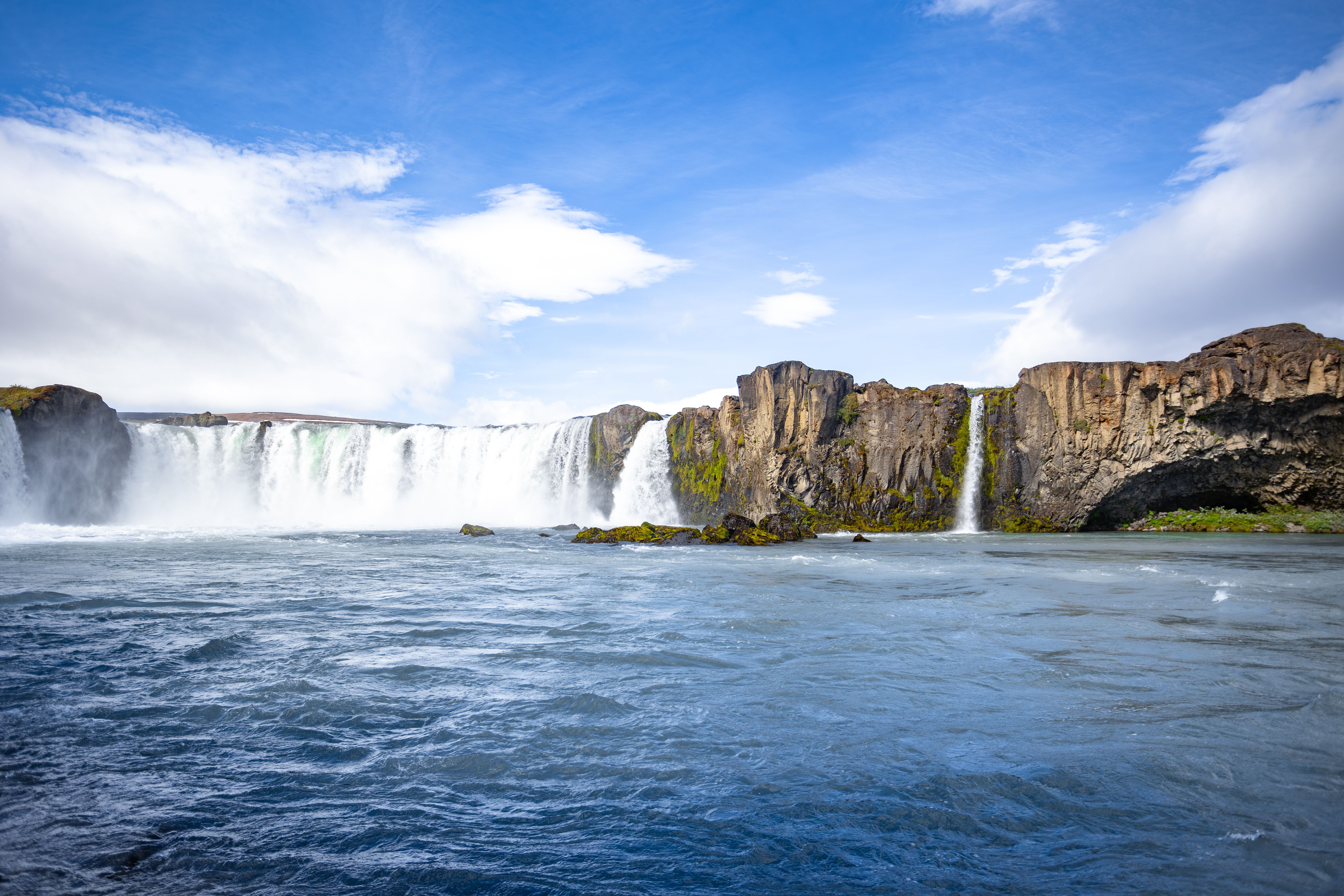 A stunning view of the Godafoss waterfall under a clear blue sky in Iceland. - Akureyri
