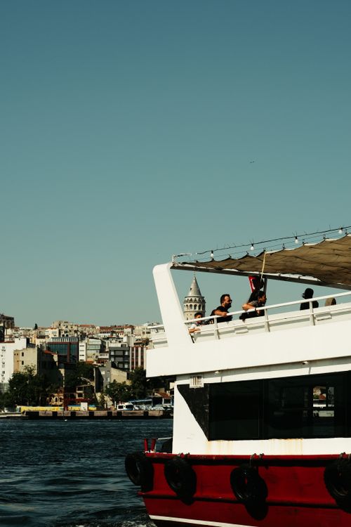 Free Ferry cruising in Istanbul with a view of the Galata Tower under clear skies. Stock Photo