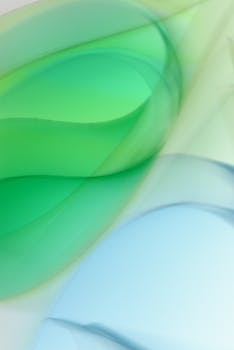Abstract image featuring dynamic green and blue waves with a smooth gradient and fluid design.
