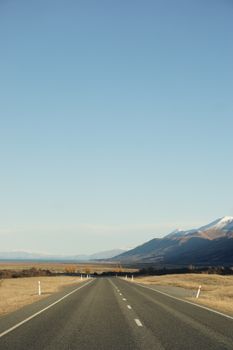 Explore the tranquil beauty of Queenstown's open road with mountains and vast skies in Otago, New Zealand.