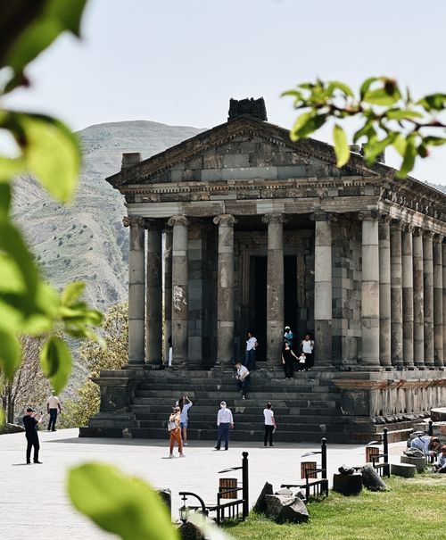 Free Stunning view of the ancient Garni Temple surrounded by visitors on a sunny day. Stock Photo